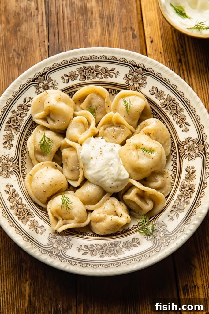 top down view of a large bowl with dumplings and a dollop of sour cream