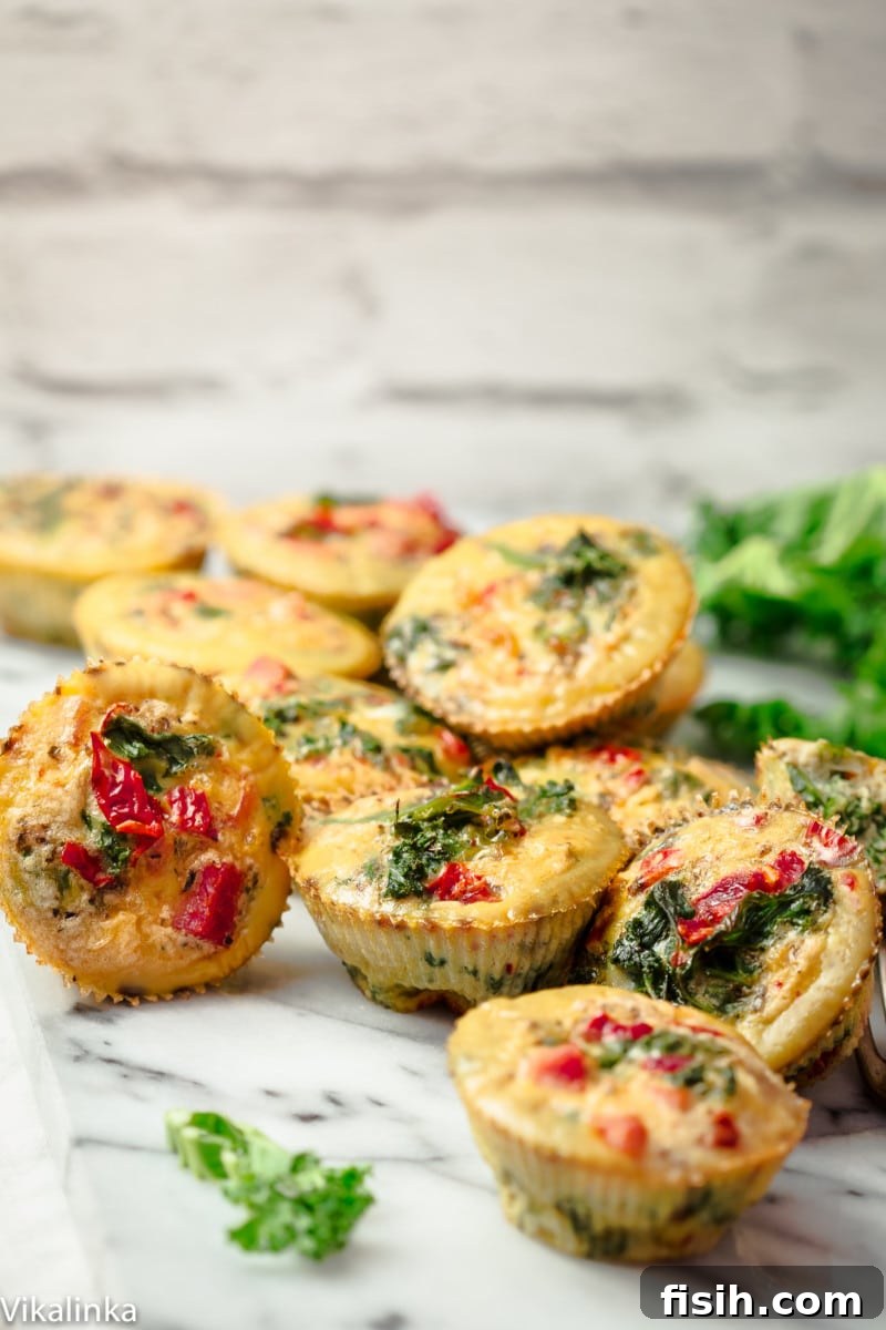 A beautiful pile of healthy mini frittatas resting on an elegant marble countertop, garnished lightly, ready to be picked up for a quick meal.