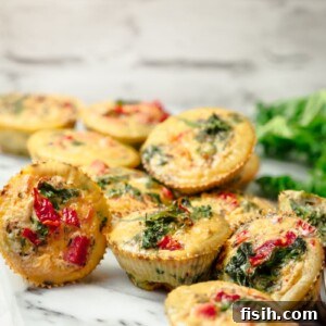 A close-up of a stack of mini frittatas on a marble surface, ready to be served.