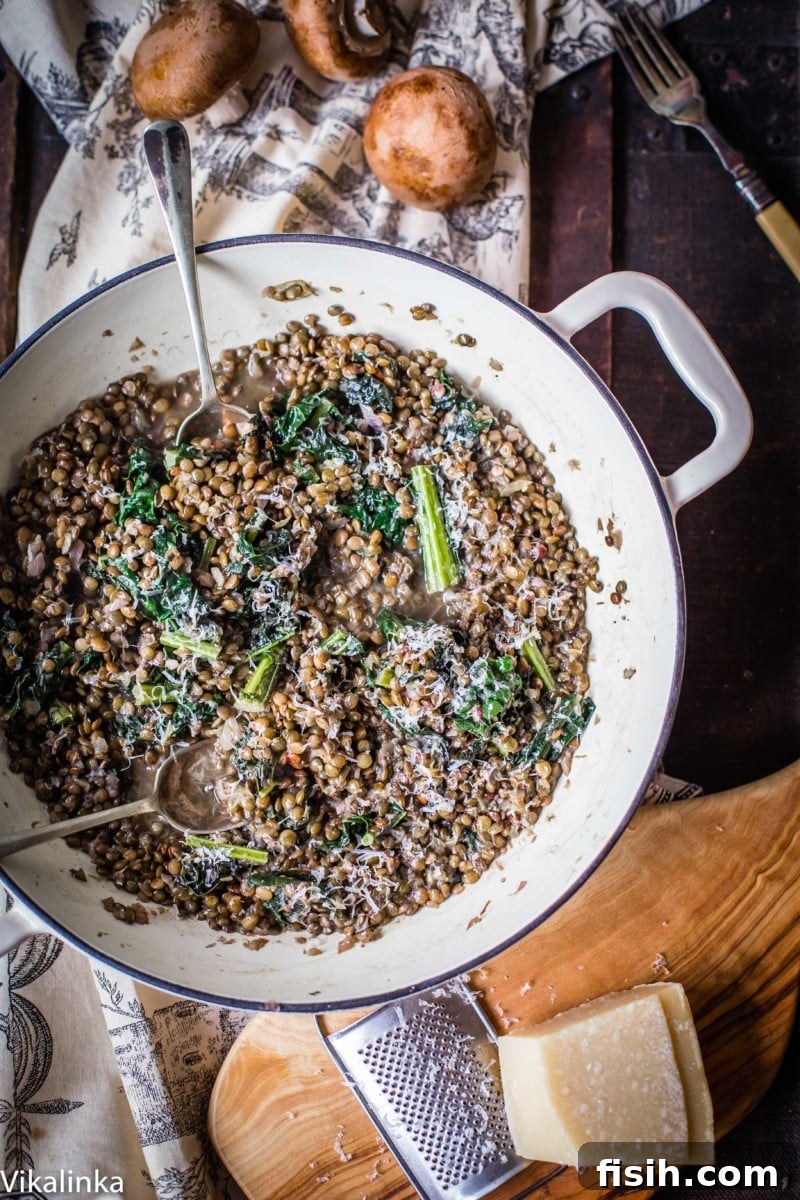 Rich and creamy green lentil 'risotto' topped with sautéed kale, showcasing its hearty texture and healthy ingredients.