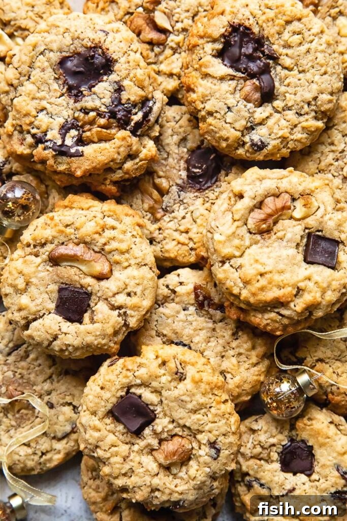 Top down shot of many cowboy cookies stacked on top of each other on a cutting board
