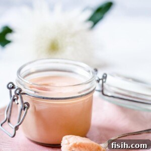 Rhubarb curd in a glass container with a spoon