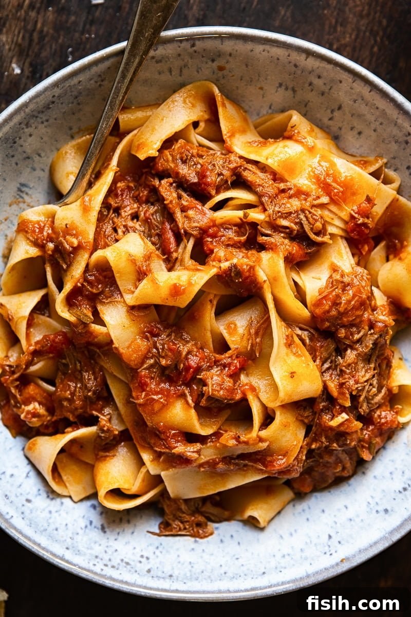 Top down of a bowl of Rustic Italian Beef Ragu with a fork