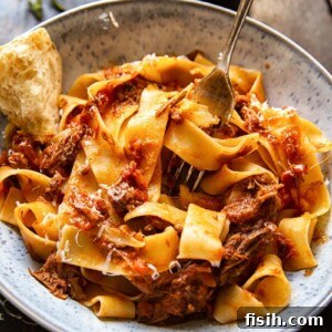 Bowl of Rustic Italian Beef Ragu with a piece of chunky bread and a fork