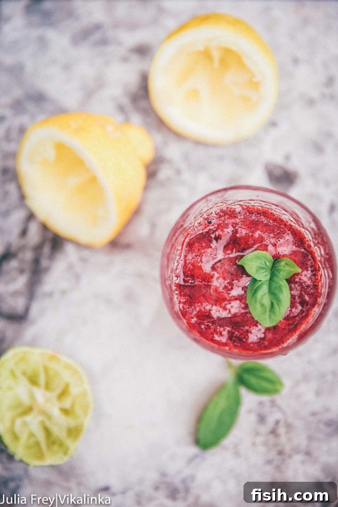 Top down view of blackberry basil lemonade with juiced lemons and limes
