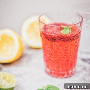 Side view of blackberry basil lemonade in a clear glasss