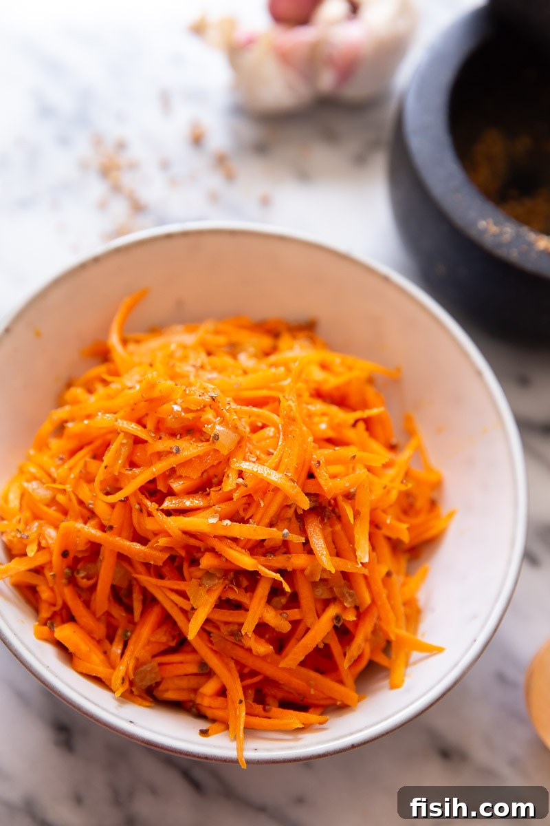 Spicy Korean Carrot Salad 3 Close-up of vibrant Korean carrot salad with spices in a white bowl.