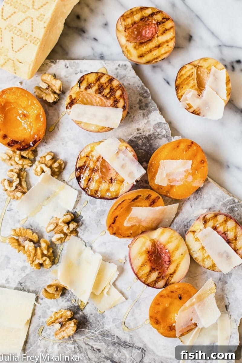Stone fruit on a marble slab with walnuts and cheese shavings