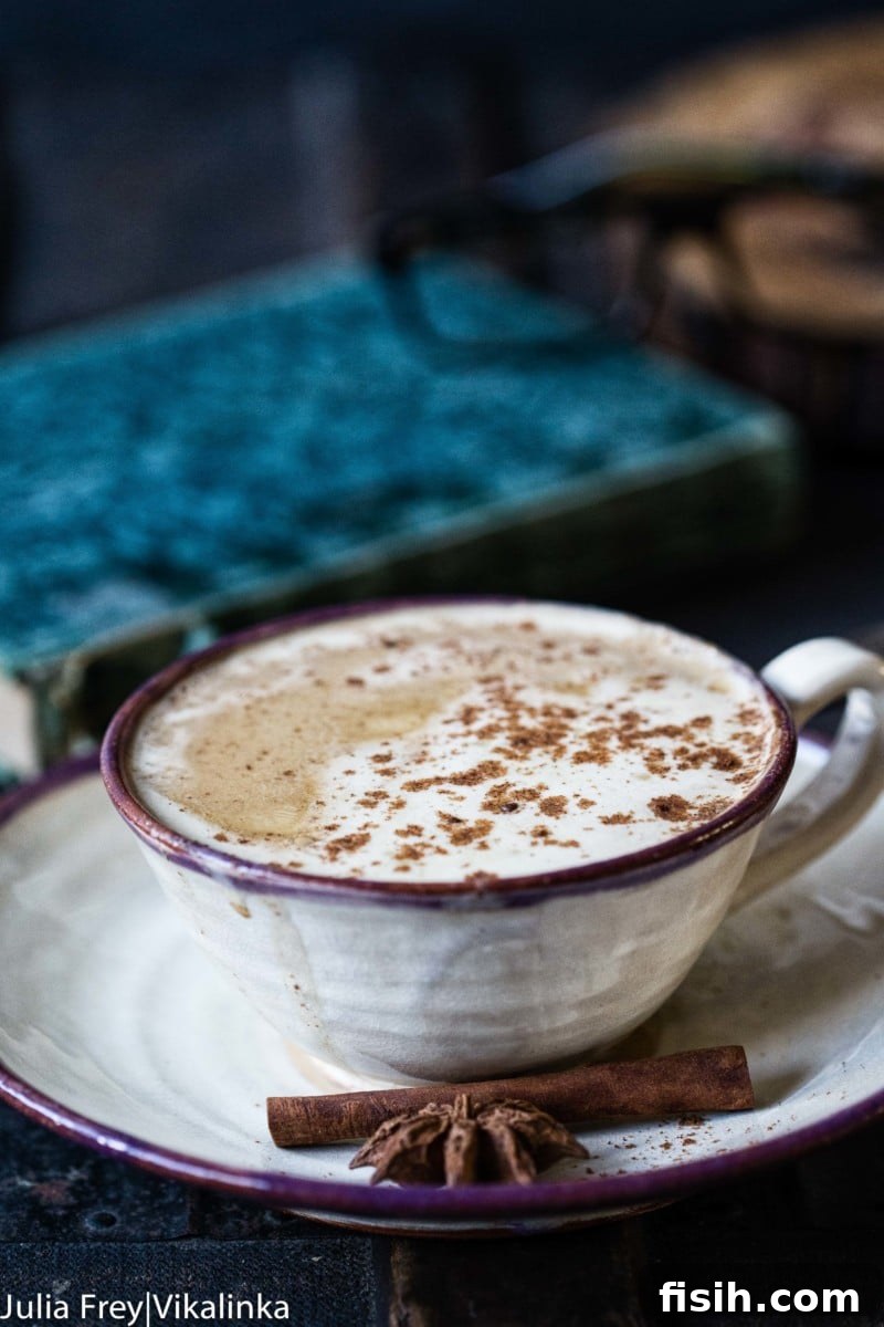 A beautifully styled mug of pumpkin spice latte, topped with whipped cream and a sprinkle of cinnamon, against a cozy autumn backdrop.