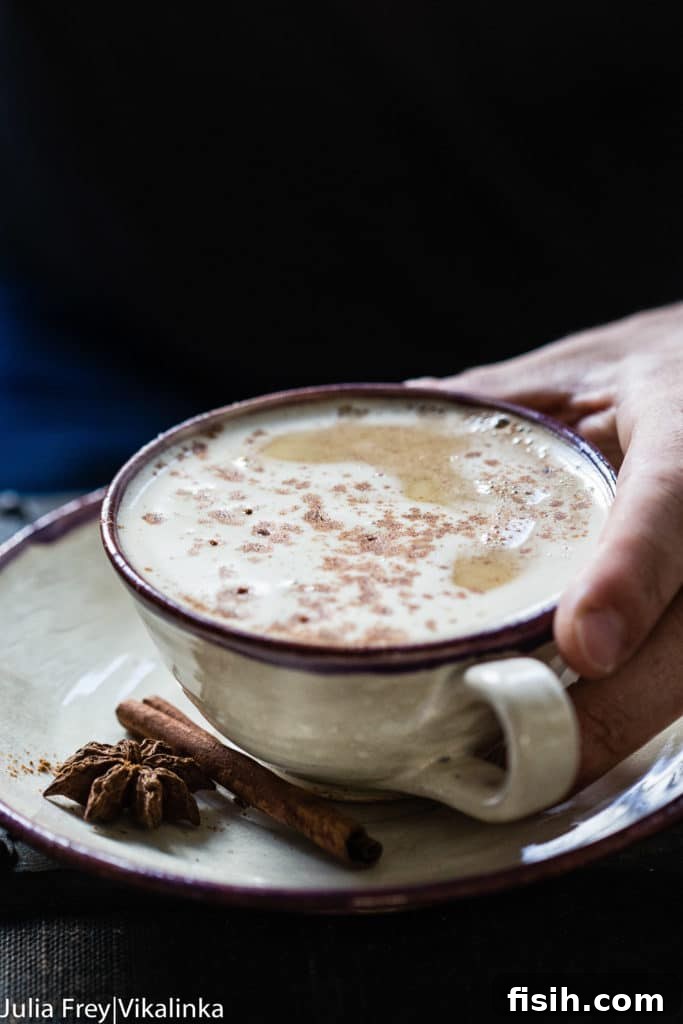 A frothy pumpkin latte in a charming ceramic mug, artfully presented on a wooden surface, ready to be enjoyed.