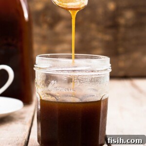 Spoon pouring pumpkin spice syrup into a jar