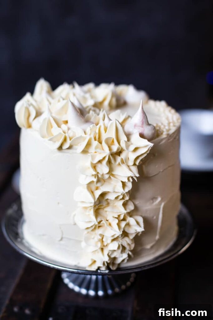 Ethereal Earl Grey Meringue 2 Earl Grey meringue cake on a cake stand, elegantly decorated.