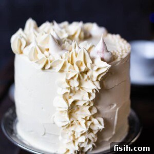 The cake on a cake stand, beautifully decorated and ready to serve.
