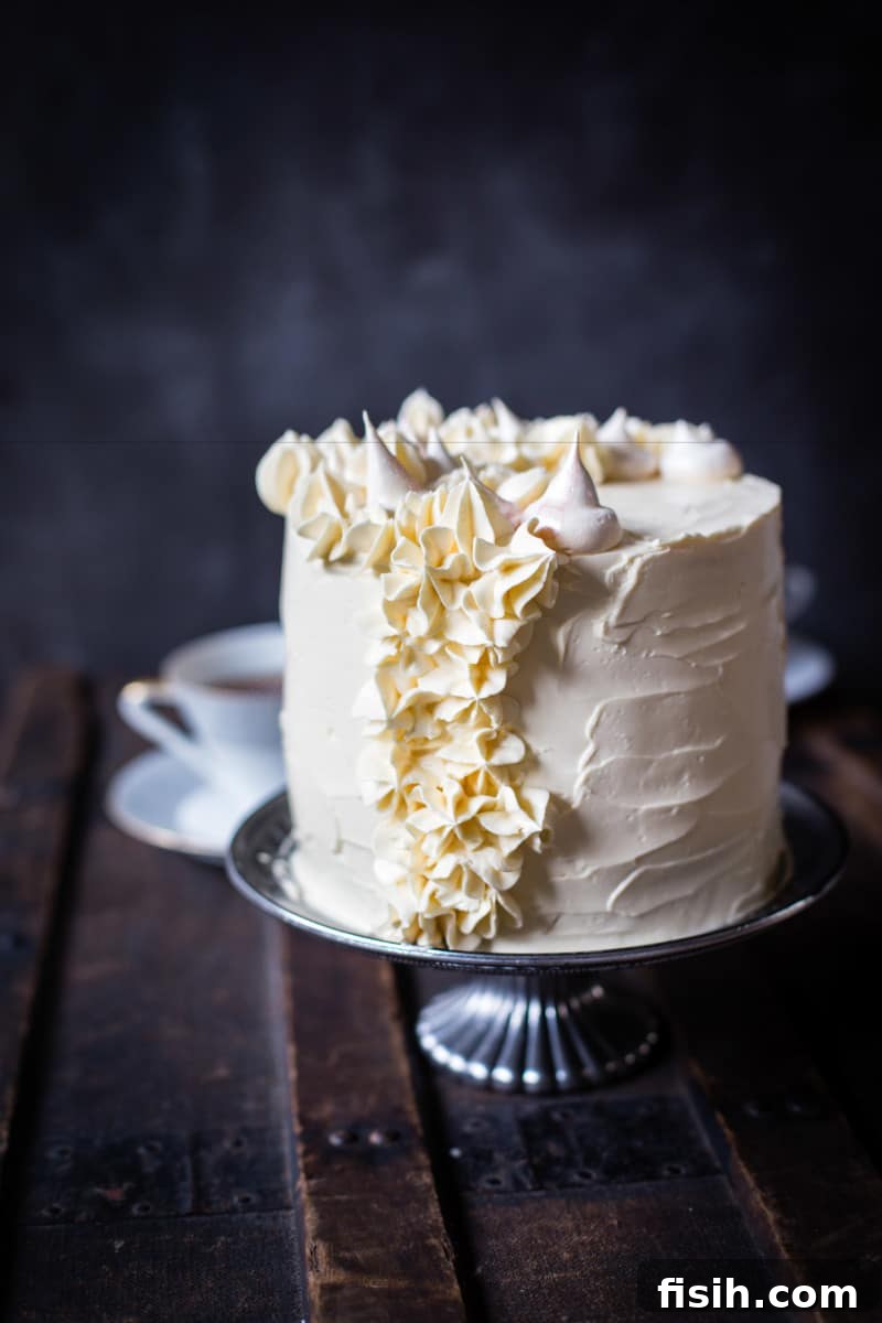 Ethereal Earl Grey Meringue 9 The fully assembled Earl Grey meringue cake on a rustic cake stand, invitingly presented on a wooden surface.