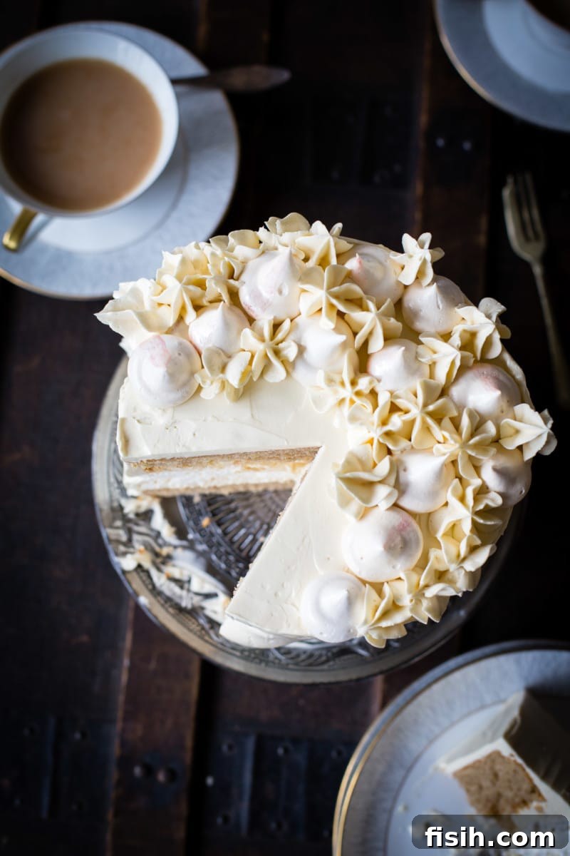 Ethereal Earl Grey Meringue 10 Top-down view of the Earl Grey meringue cake with a single slice removed, invitingly showing its internal structure and decoration.