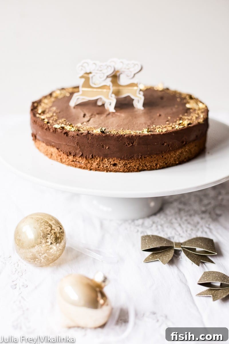 A stunning Dark Chocolate Truffle Cake, adorned with edible gold leaf, presented elegantly on a white cake stand.