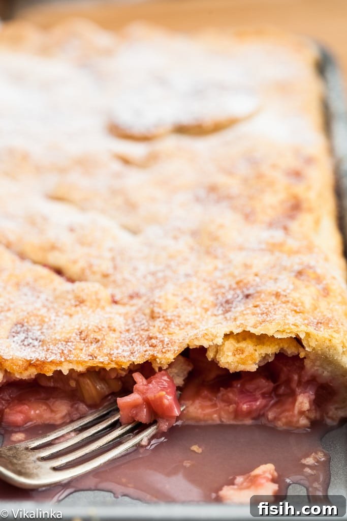 Generous Rhubarb Slab Pie 4 Close-up cross-section of a baked rhubarb slab pie slice, revealing the juicy rhubarb filling and crisp crust.