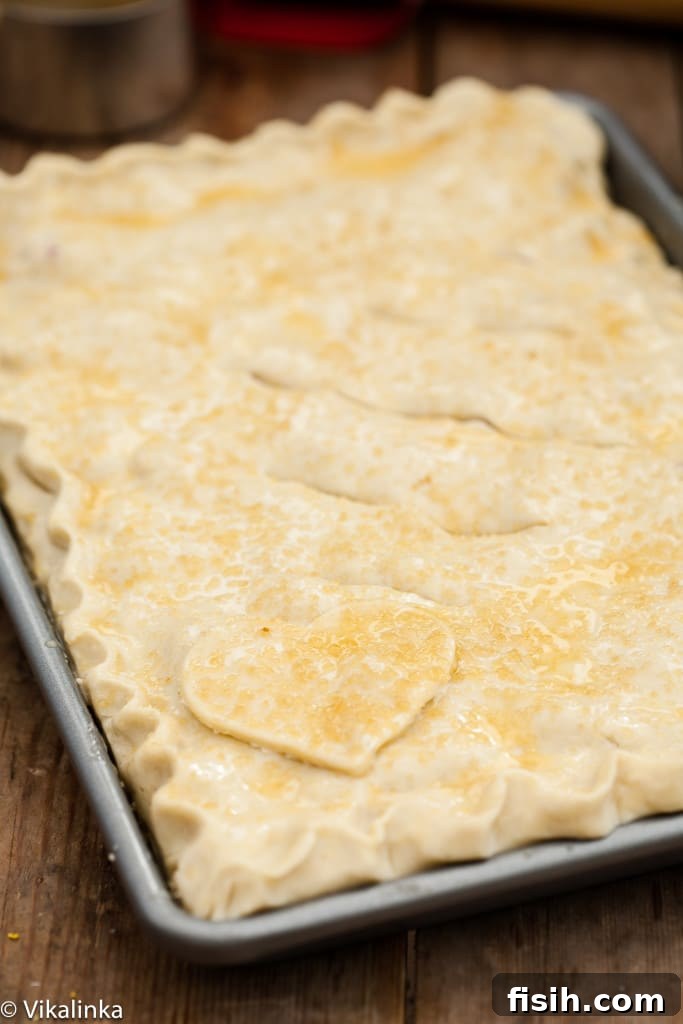 Generous Rhubarb Slab Pie 5 Process shot of the unbaked rhubarb slab pie top crust, brushed with egg wash and sprinkled with sugar.