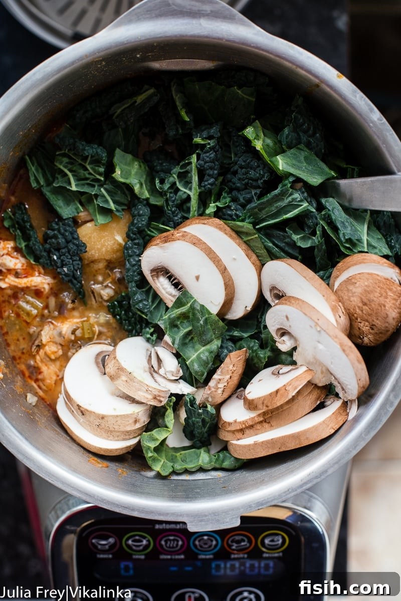 Creamy Coconut Thai Chicken and Rice Soup 5 sliced mushrooms and kale in a pot of soup