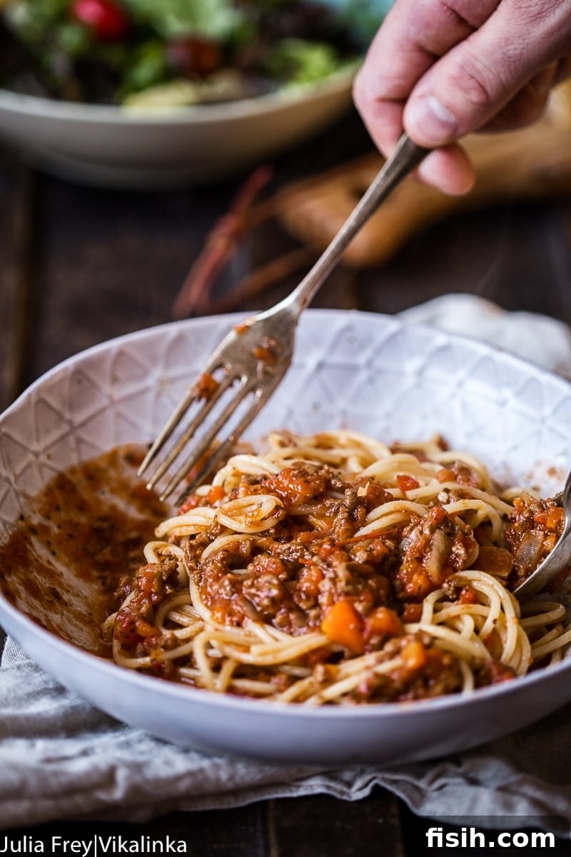Effortless Slow Cooker Bolognese 3 Close-up shot of slow cooker beef bolognese sauce simmering, showing its rich texture and color.