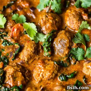 meatballs in sauce topped with cilantro leaves
