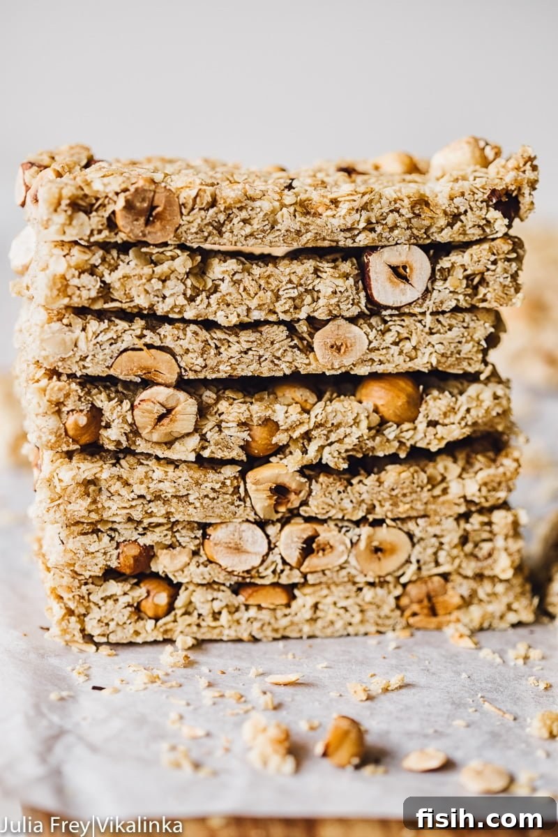 Stack of Manuka Honey and Oats Granola Bars on parchment paper, ready to be enjoyed.