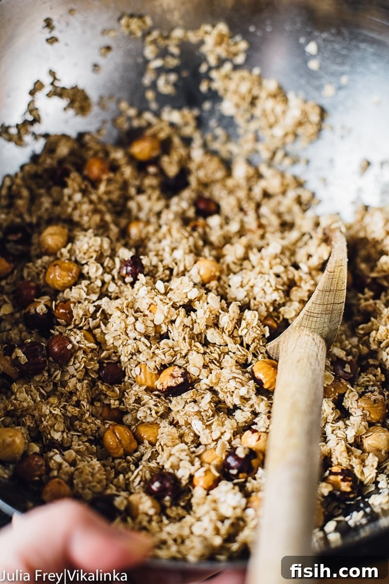 A large mixing bowl filled with the raw granola bar mixture, showcasing the texture of oats, nuts, and honey before baking.