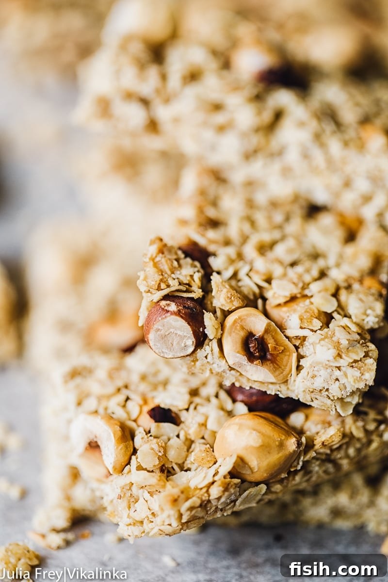A close-up view of the granola bar mix, highlighting the texture of the oats and the inclusion of whole hazelnuts.