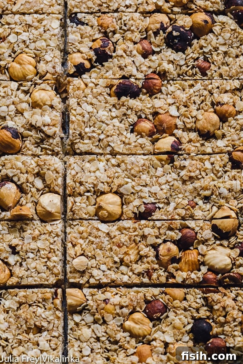 Overhead shot of freshly baked Manuka Honey and Oats Granola Bars, cut into neat squares, ready for serving.
