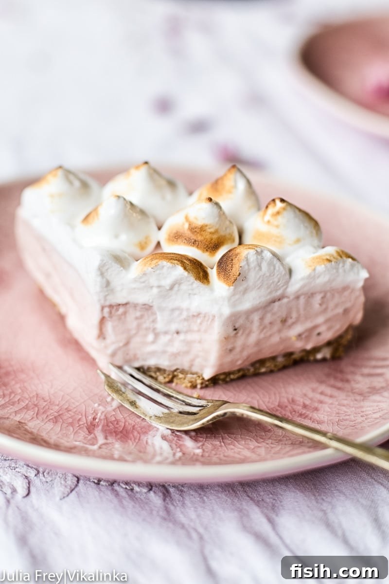 Piece of cheesecake with one piece removed by fork