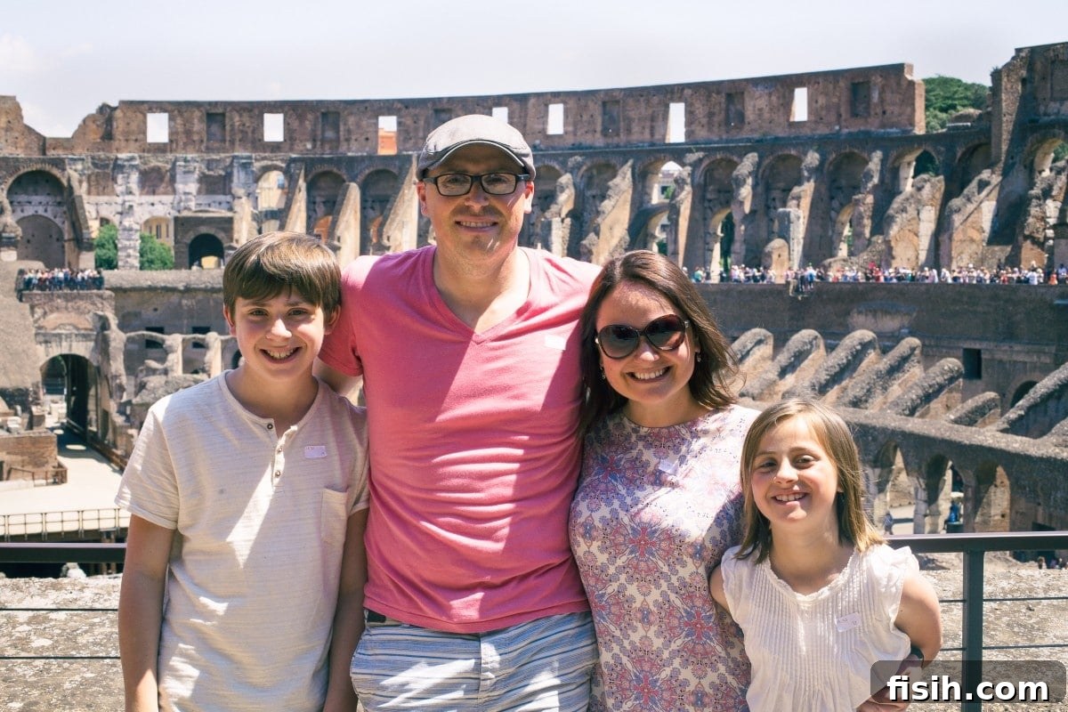 A family poses for a photo outside the majestic Colosseum in Rome