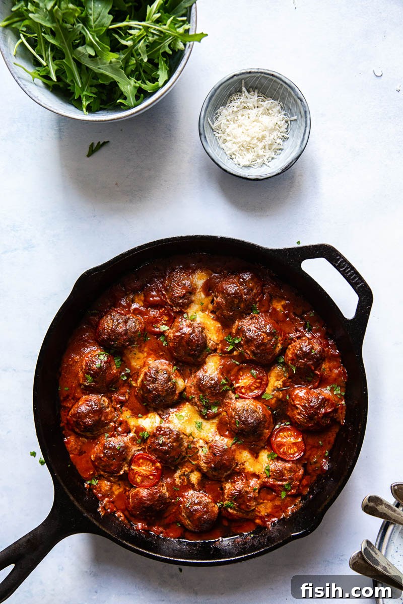 Baked meatballs served on a bed of pasta with fresh basil