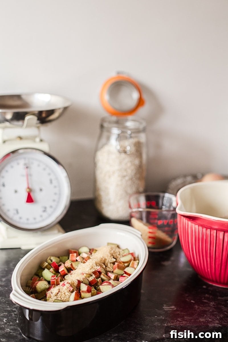Assortment of raw ingredients for Rhubarb Cobbler on a kitchen counter, with baking dishes.