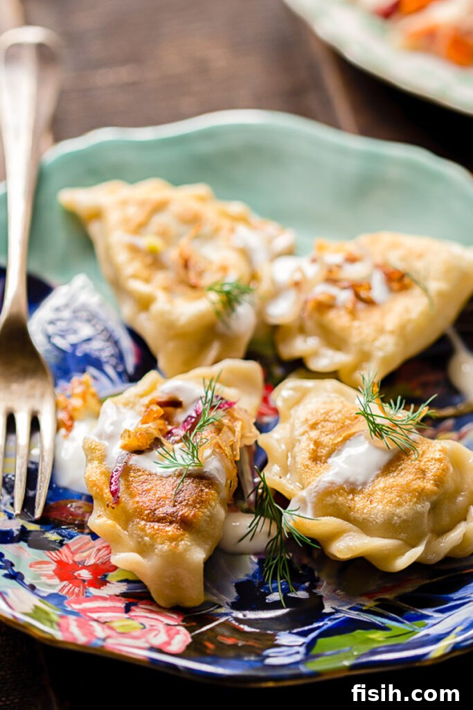 Smoky Bacon and Sweet Onion Potato Pierogi 3 A plate of golden-brown Vareniki, garnished with fresh dill and served with a fork, inviting a taste.