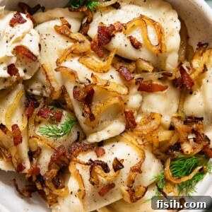 A bowl of freshly cooked Vareniki, topped with crispy fried onions and bacon bits, ready to be enjoyed.