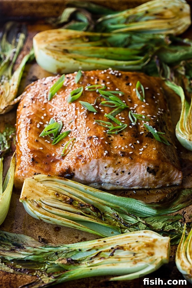 Close-up of perfectly cooked salmon teriyaki with vibrant green bok choy.