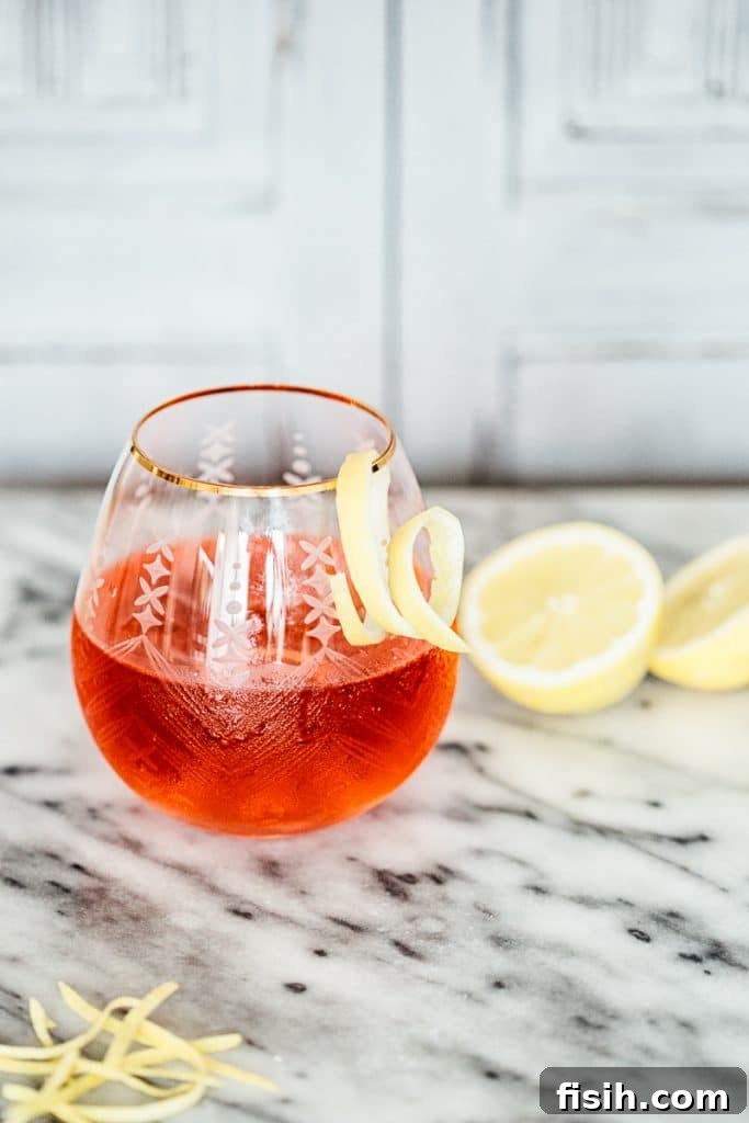 Elevate Your Gin and Tonic Three Ways 4 Side shot of Hibiscus and Lemon Gin and Tonic In a glass with a lemon swirl