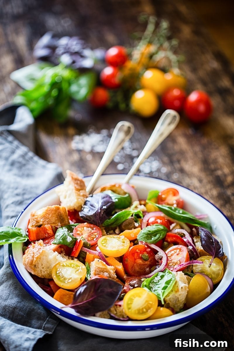 Rustic Tuscan Bread Salad 4 A beautifully arranged Tuscan Panzanella Salad in a white bowl with a blue rim, showcasing its fresh ingredients.