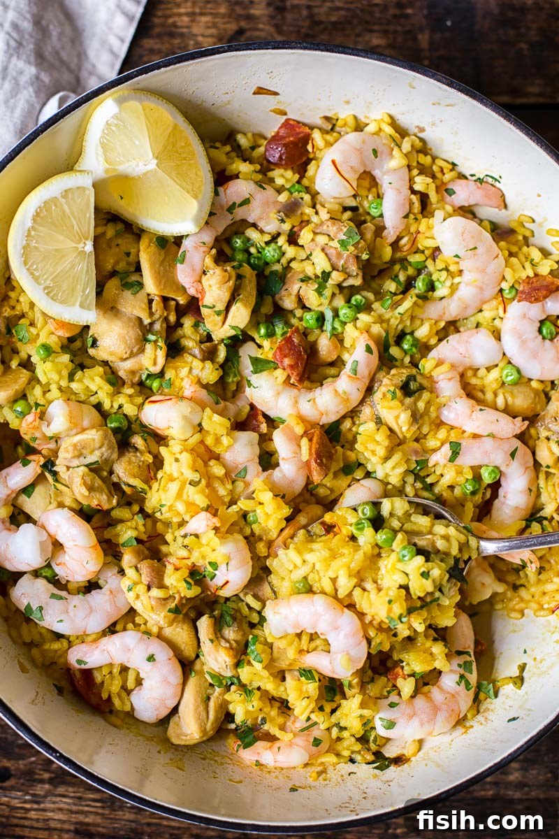 top down view of yellow Spanish rice with chicken, shrimp and lemon slices