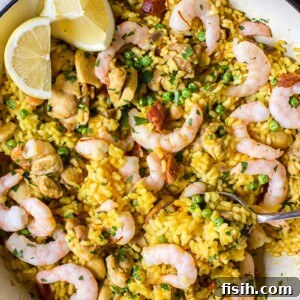 top down view of yellow Spanish rice with chicken, shrimp and lemon slices