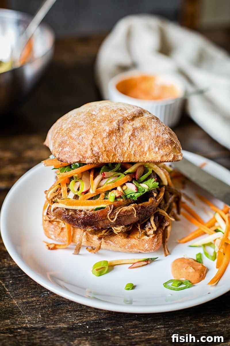 Fusion Pulled Pork Sandwiches with Zesty Root Vegetable Slaw 5 Asian pulled pork sandwich on a plate from the side