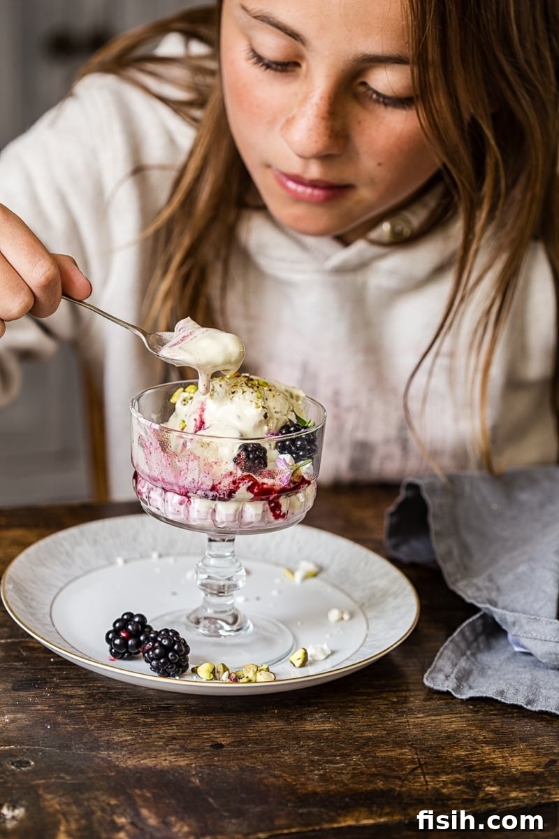 Girl eating the dessert from a glass dish