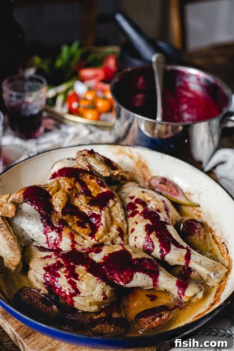 Georgian Tabaka Chicken with Fiery Blackberry Glaze 4 A spatchcocked chicken simmering with blackberry sauce in a large cooking pan, showcasing the rich colors and textures of the dish.