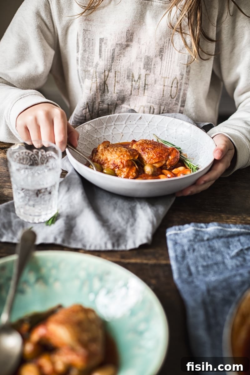 A person enjoying a bowl of Italian Rosemary Chicken Stew with a fork, capturing the comfort of the meal.