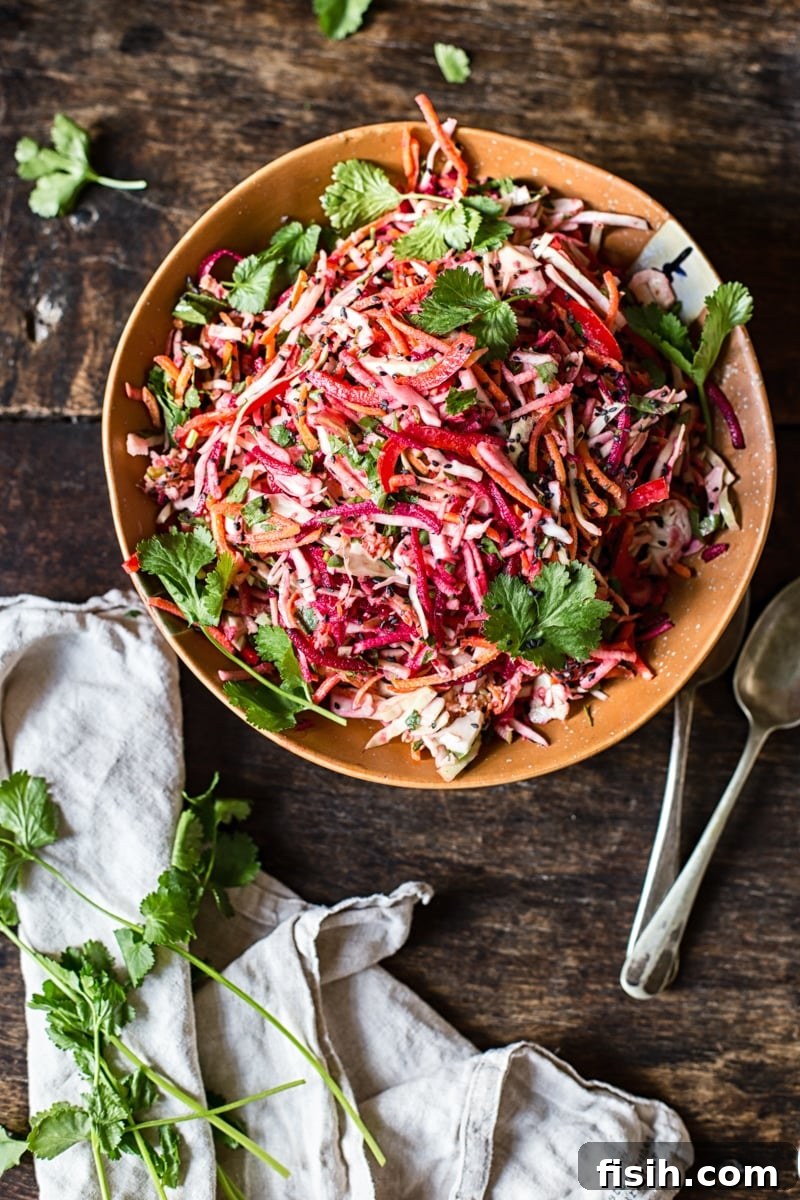 Vibrant Slaw, Zesty Tahini Delight 4 Top-down view of a colorful bowl of rainbow slaw with dressing drizzled