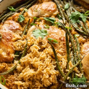 Golden-brown coconut chicken and rice with vibrant green beans, served in a white baking dish, ready for a delicious meal.