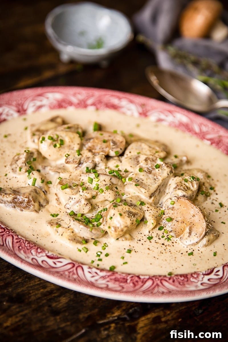 Plate of beef in truffled cream sauce with fresh herbs, ready to be served