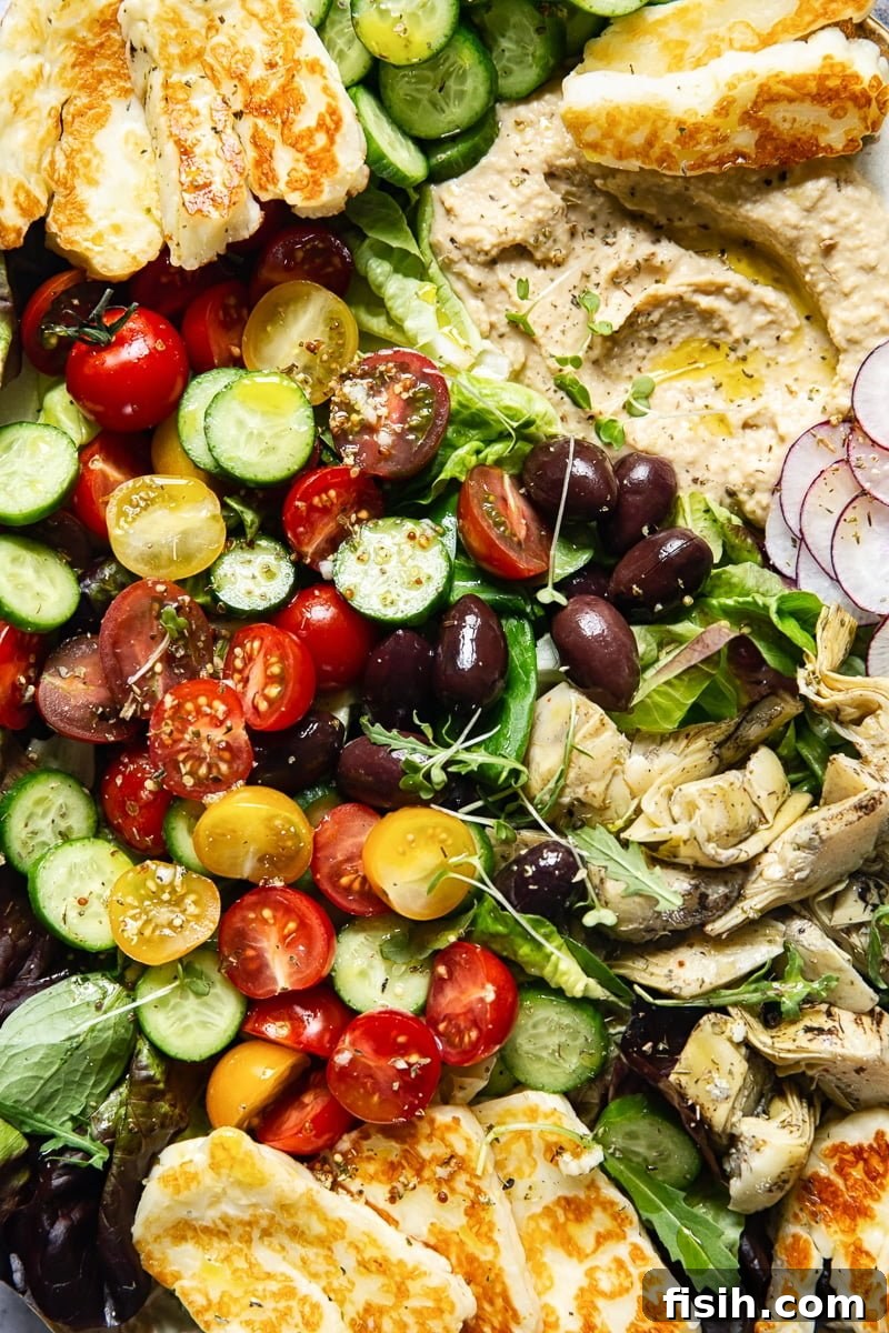 Golden Halloumi & Hummus Mediterranean Salad 5 Close up of fresh cherry tomatoes and other salad ingredients, forming a colorful base for the Mediterranean salad.
