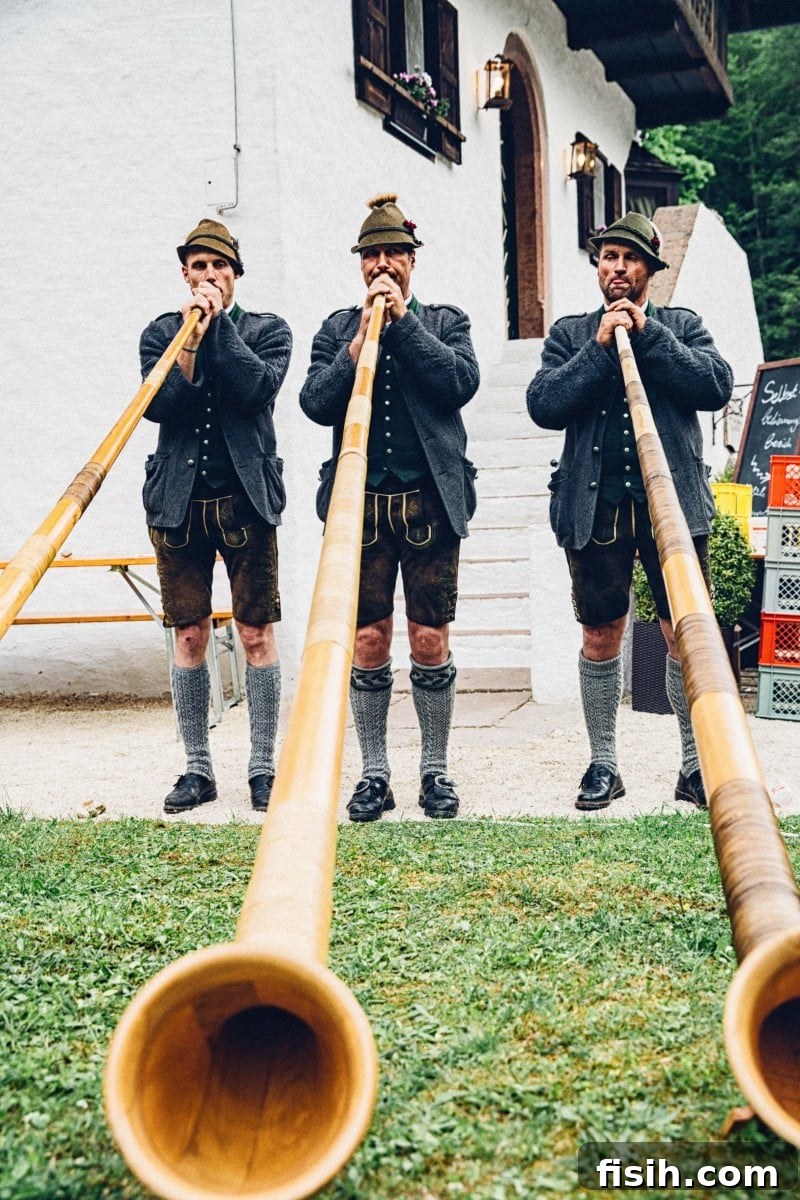 Three alphorn players in traditional lederhosen performing outdoors, celebrating Austrian culture