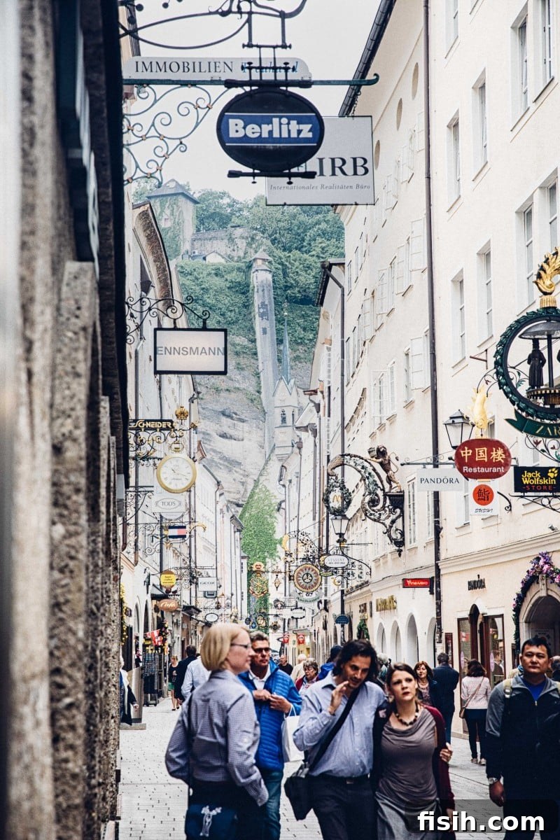 Historic Getreidegasse, Salzburg's bustling main shopping street, featuring ornate guild signs